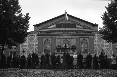 Festspielhaus. Trumpetare ur orkestern står på den kungliga logens balkong och signalerar med ett ledmotiv ur kvällens föreställning att det är dags för publiken att dra sig inåt.